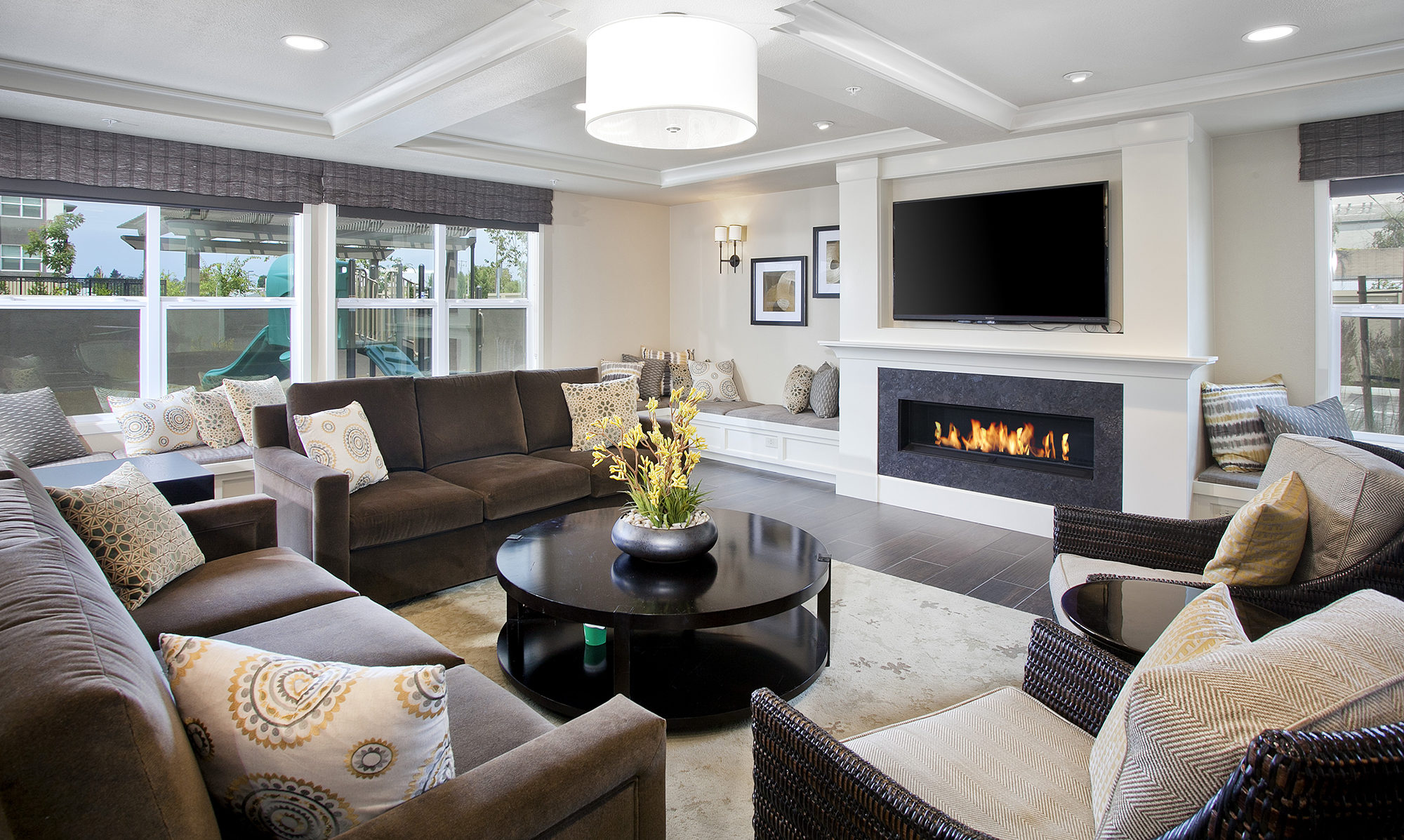 Clubhouse space with fireplace, brown sofas and large television.